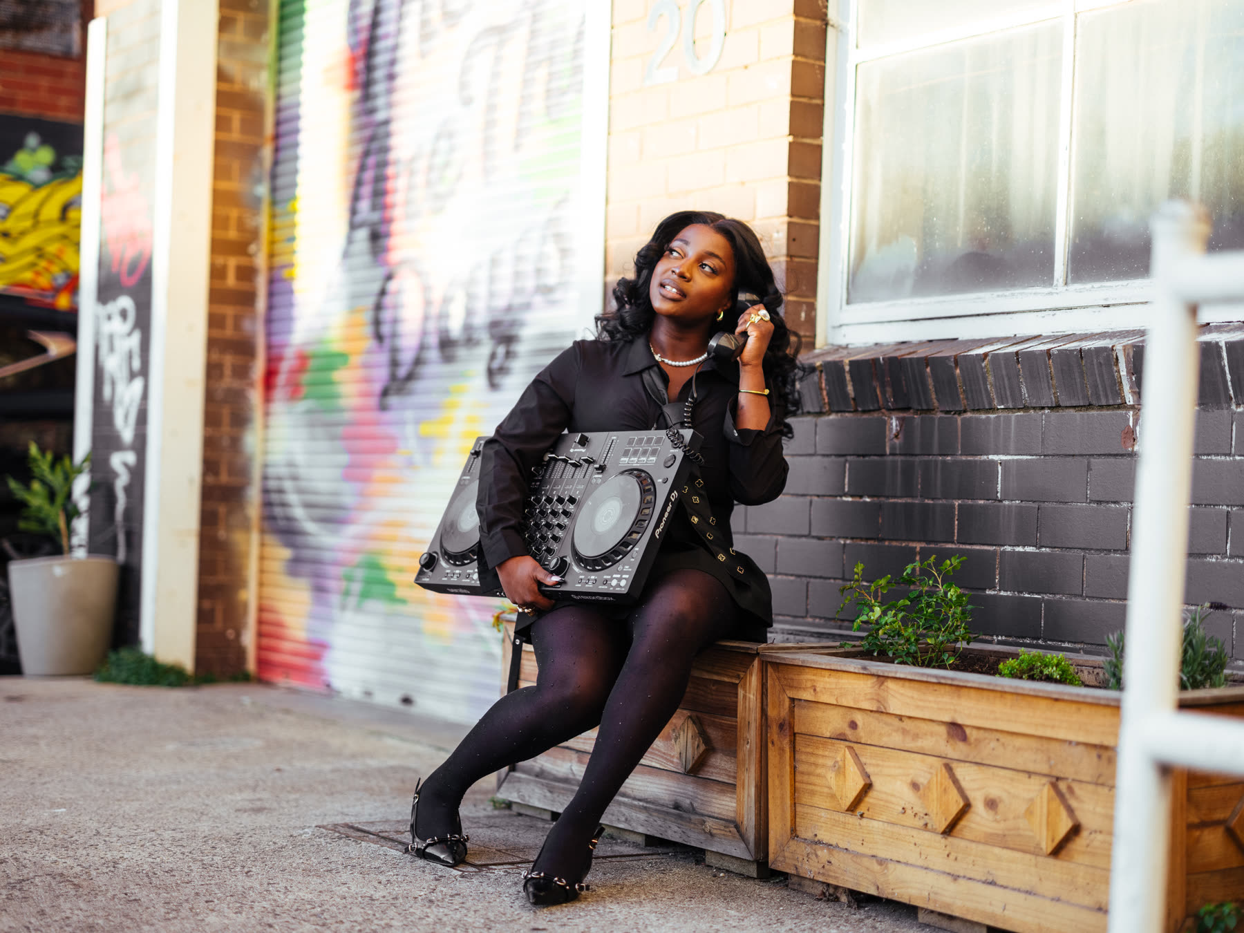 VTKAY with her DJ controller by a Melbourne graffiti wall